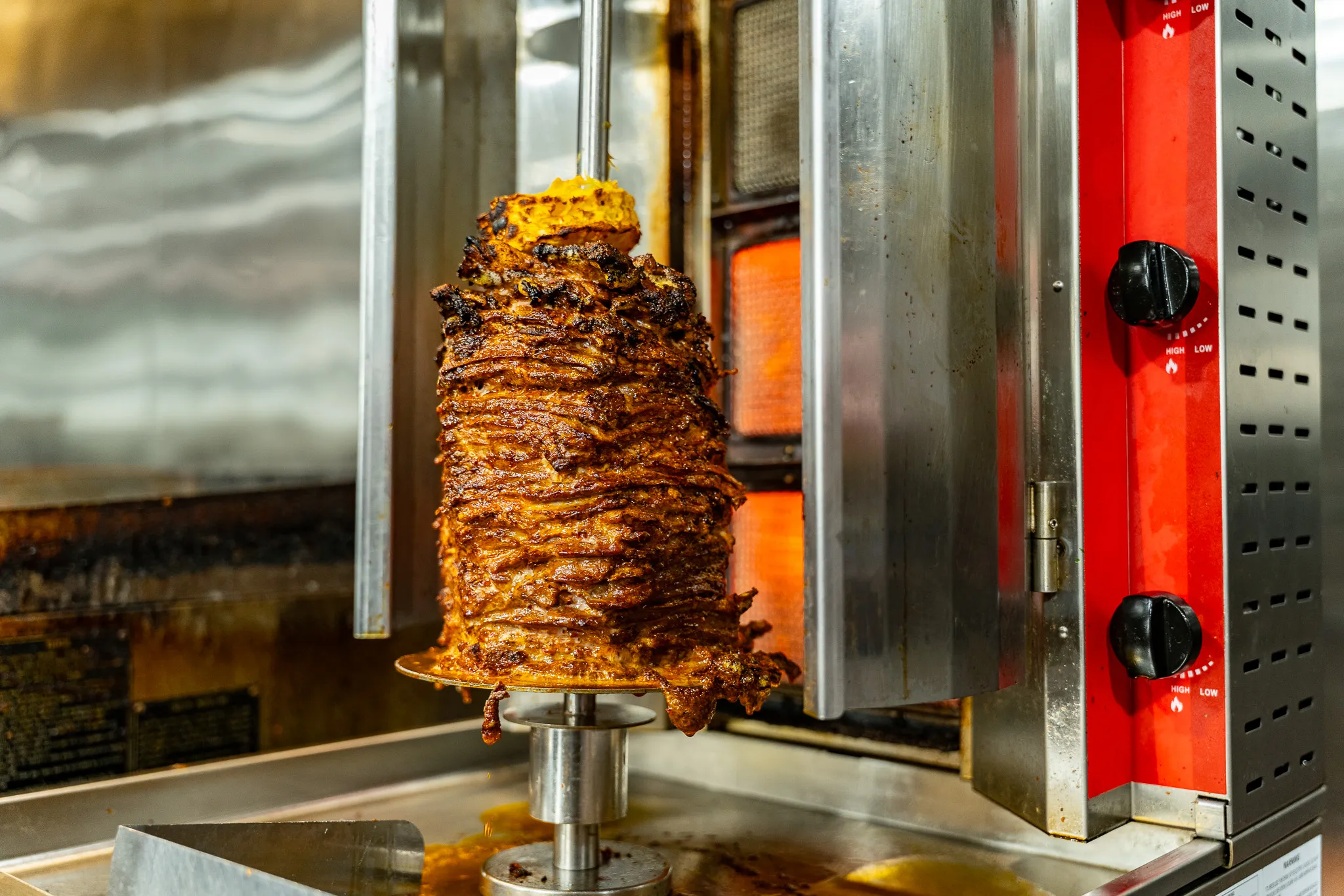 Al pastor trompo of marinated pork on the vertical spit at the express deli