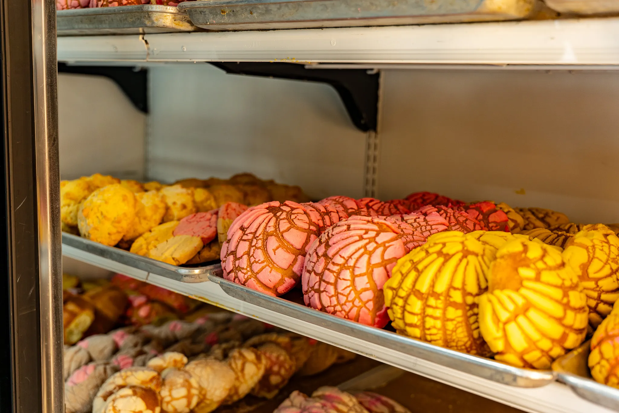 Glass deli case filled with fresh-prepared Mexican foods and golden specialties