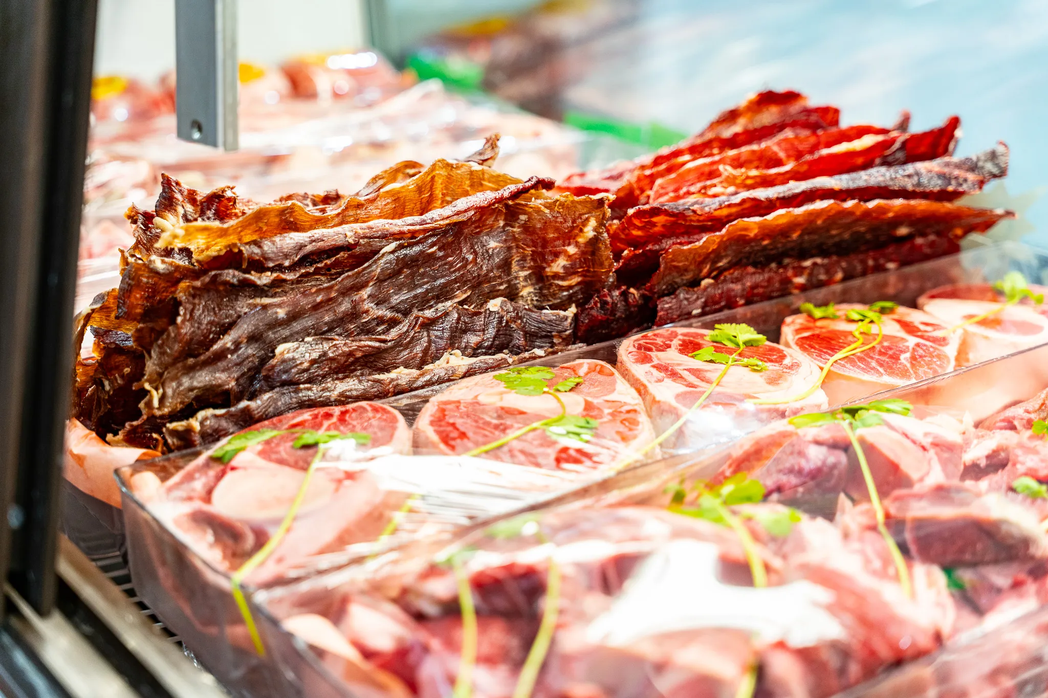 House-marinated carne adobada and seasoned meats in the refrigerated meat case